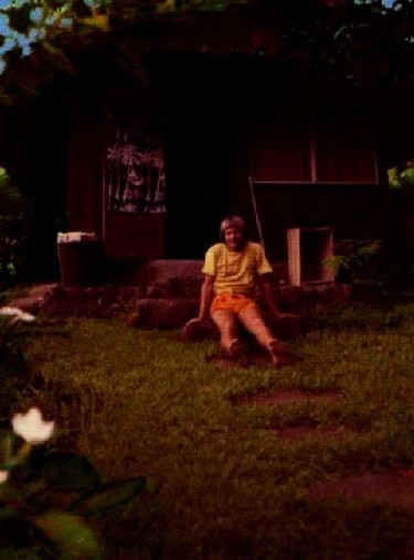 Ron Marlett sitting in front of his Tahitian hut.